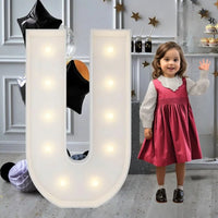 Lettre marquee 120 cm – la lettre U allumée à côté d'une petite fille