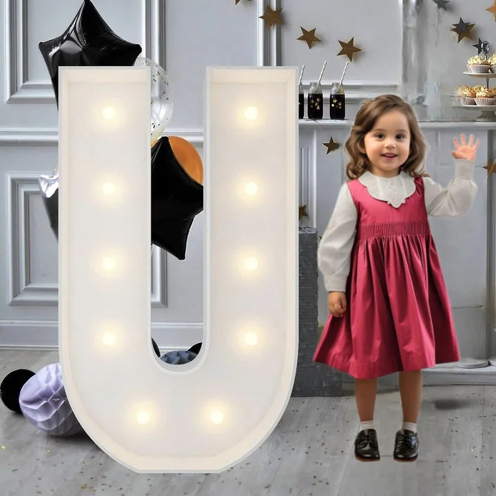 Lettre marquee 120 cm – la lettre U allumée à côté d'une petite fille