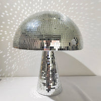 Boule à facettes déco champignon – champignon argenté posé sur une table avec reflets de lumière