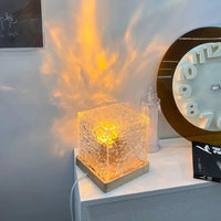 Lampe cristal ondulation d'eau – lampe allumée près d'une horloge, reflets ambrés sur le mur