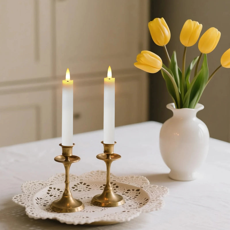 Bougies LED coniques – deux bougies blanches sur chandeliers dorés près de tulipes