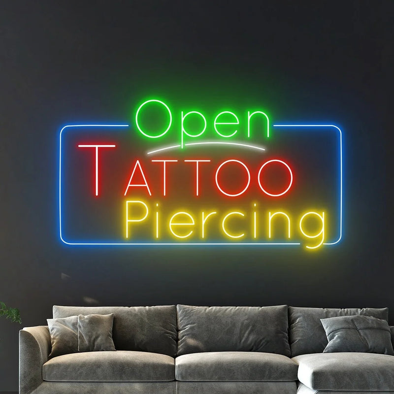 Enseigne néon Open Tattoo Piercing – au-dessus d'un canapé gris