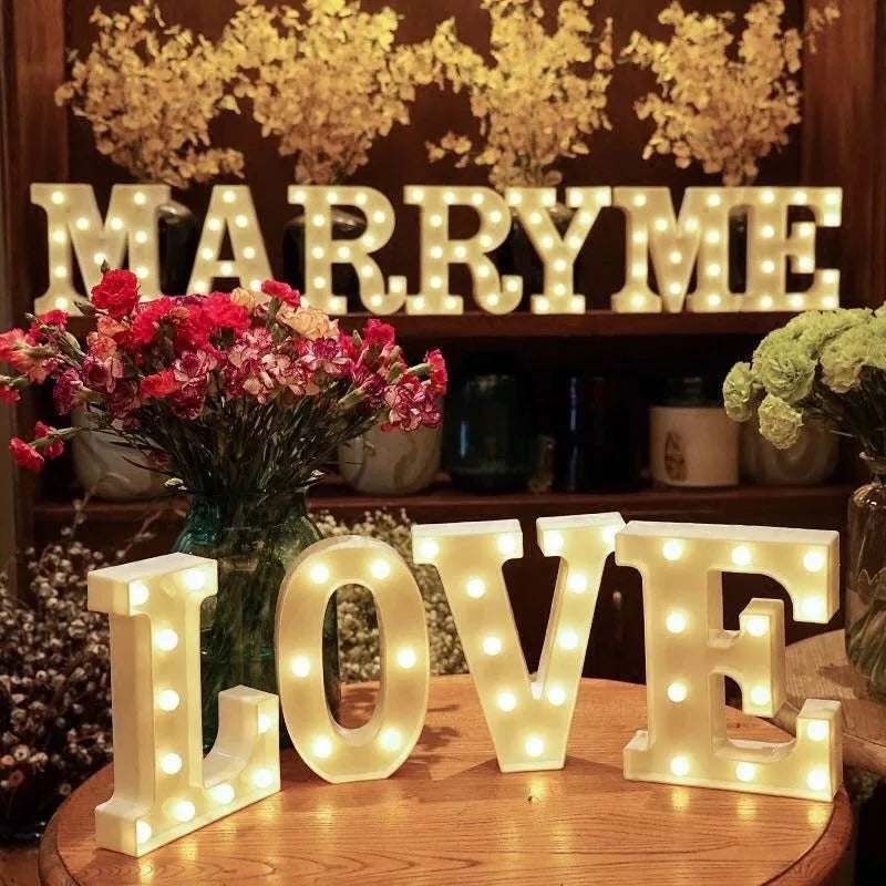 Lettres et chiffres lumineux LED à piles – MARRY ME et LOVE composés sur une table fleurie