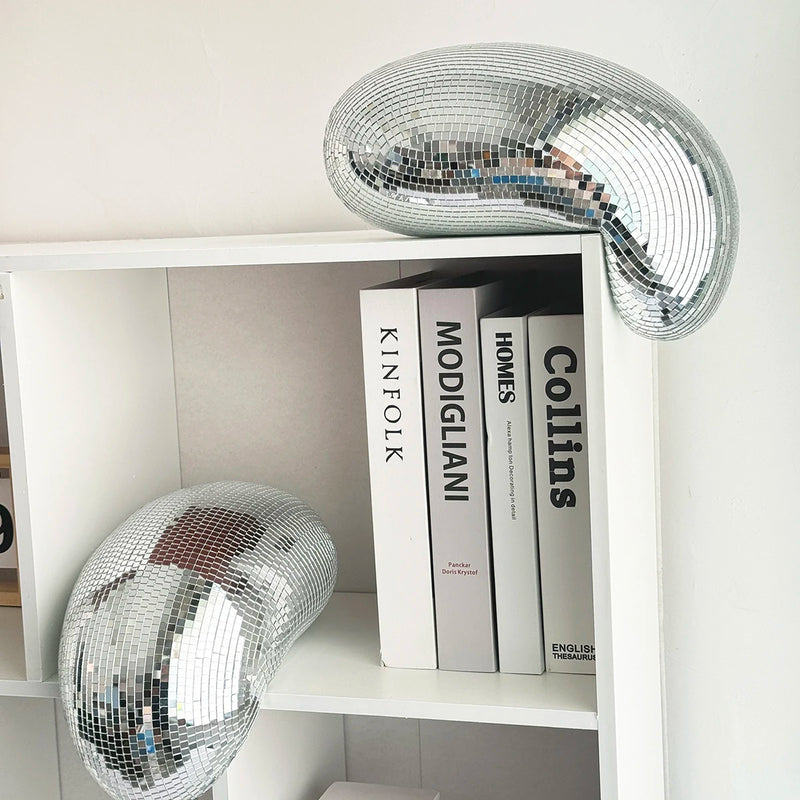 Boule à facettes déco fondue – boule argentée sur une étagère près de livres