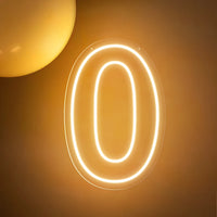 Chiffre néon LED blanc chaud – le chiffre 0 allumé sur un mur doré