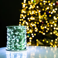 Guirlande fil vert – bobine allumée en blanc froid devant un sapin