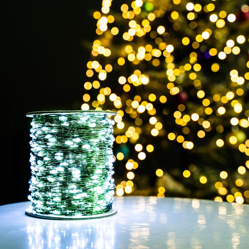 Guirlande fil vert – bobine allumée en blanc froid devant un sapin