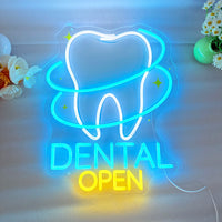 Enseigne néon dentiste DENTAL OPEN – gros plan sur un mur clair avec des fleurs