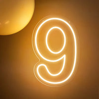 Chiffre néon LED blanc chaud – le chiffre 9 allumé sur un mur doré