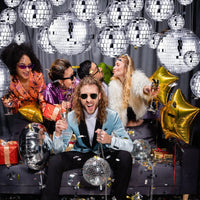 Boule à facettes argentée déco – amis en soirée sous des boules à facettes suspendues
