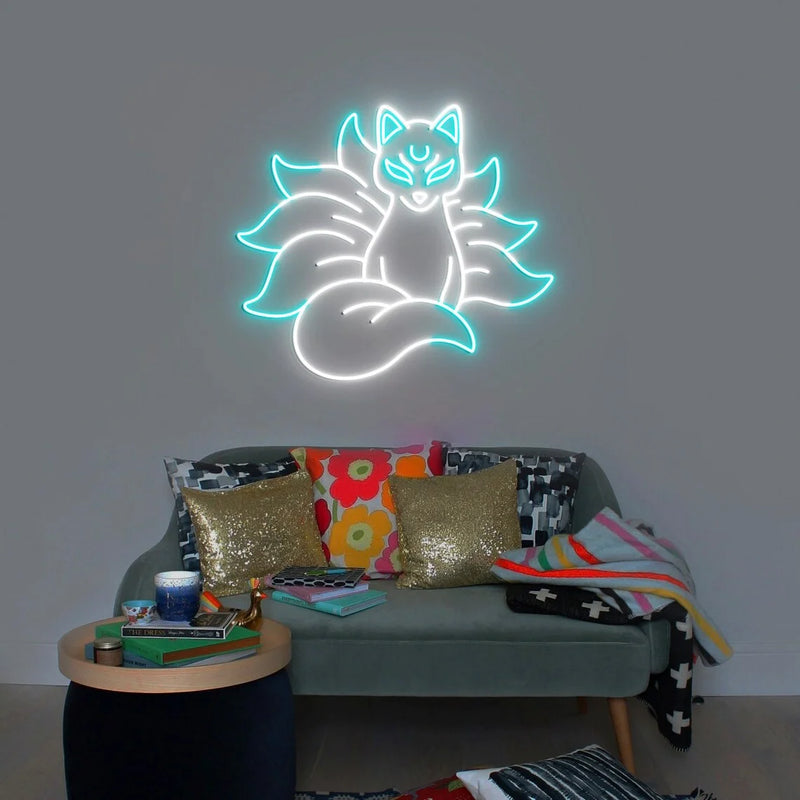 Néon renard kitsune – coloris blanc et turquoise allumé au-dessus d'un canapé