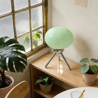 Lampe champignon en verre – globe vert posé sur une étagère en bois