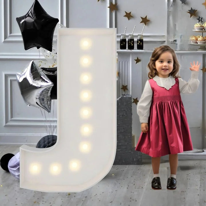 Lettre marquee 120 cm – la lettre J allumée à côté d'une petite fille