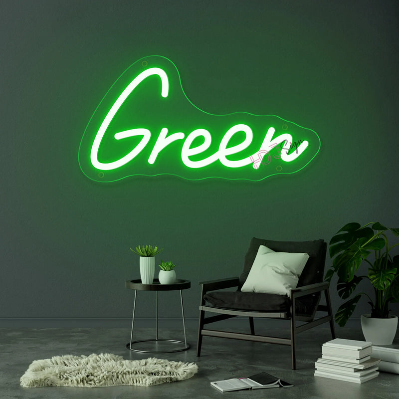 Néon prénom personnalisé cœur ou couronne – texte vert sur un mur gris au-dessus d'un fauteuil