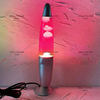Lampe à lave géante 41 cm – cire blanche et liquide rose allumée devant un mur