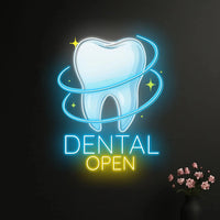 Enseigne néon dentiste DENTAL OPEN – sur un mur noir avec un vase de fleurs roses