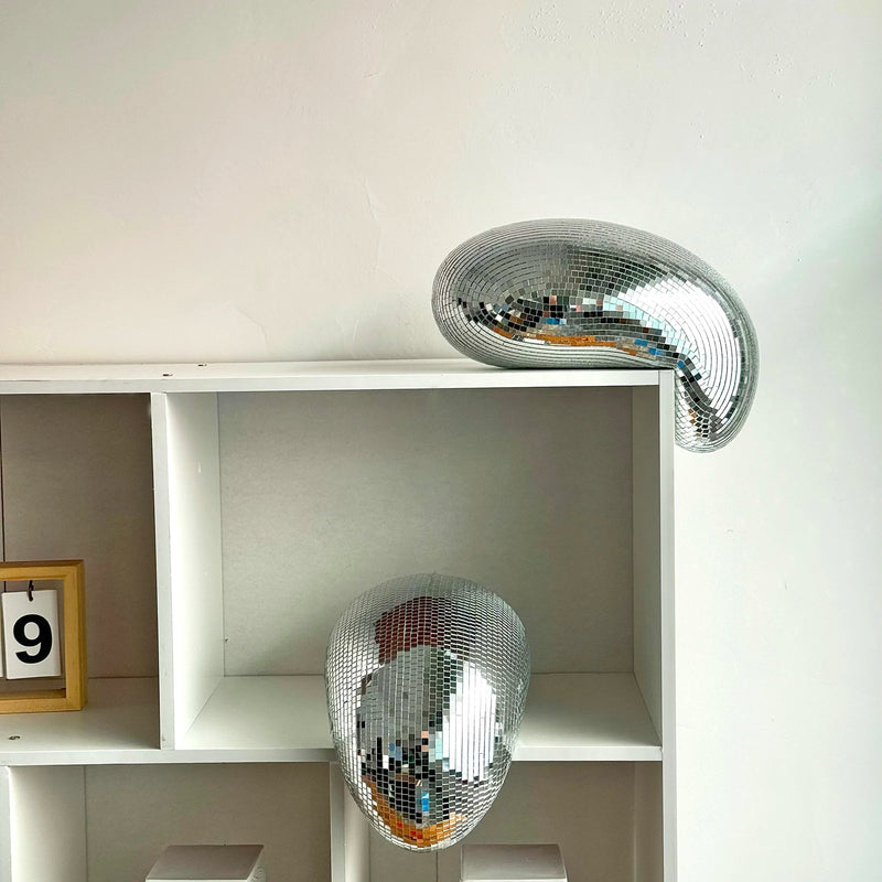 Boule à facettes déco fondue – deux boules dans une bibliothèque blanche