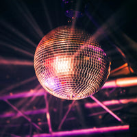 Boule disco argentée 30 cm – boule éclairée par des projecteurs colorés sur une scène