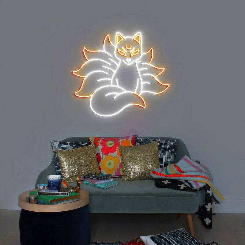 Néon renard kitsune – coloris blanc et orange allumé au-dessus d'un canapé