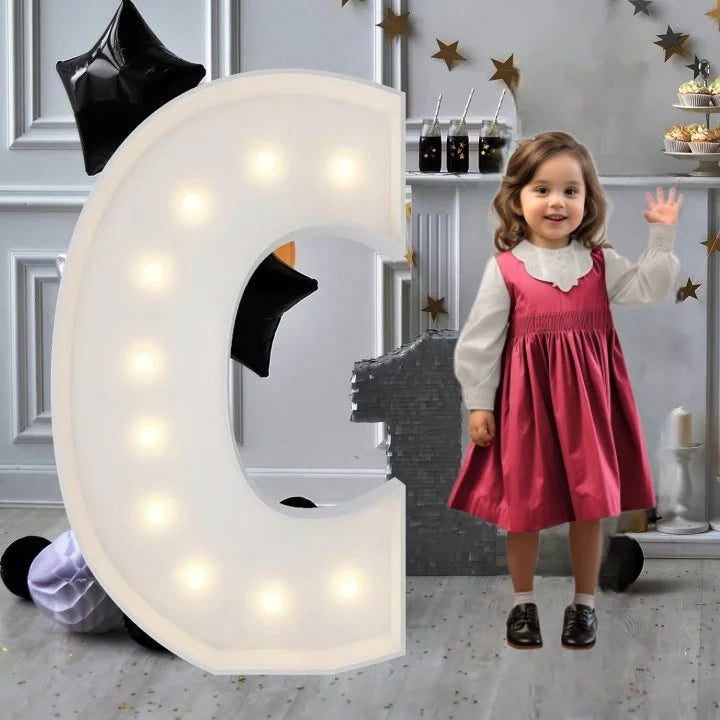 Lettre marquee 120 cm – la lettre C allumée à côté d'une petite fille