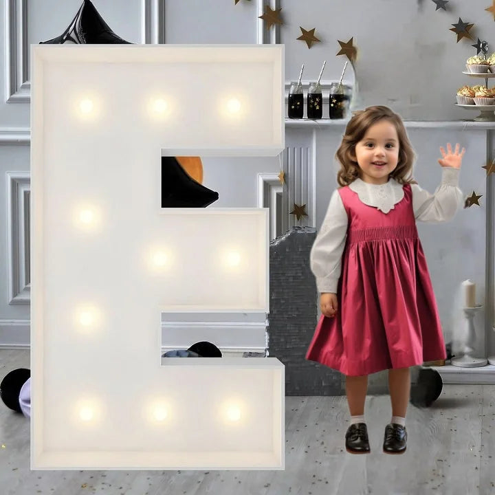 Lettre marquee 120 cm – la lettre E allumée à côté d'une petite fille