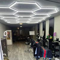 Plafonnier LED nid d'abeille – plafond hexagonal dans un salon de barbier