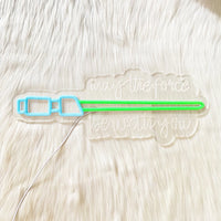 Néon sabre laser – enseigne éteinte posée sur un tapis blanc