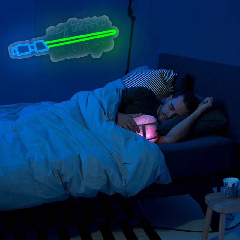 Néon sabre laser – enseigne allumée au-dessus d'un lit dans une chambre bleutée