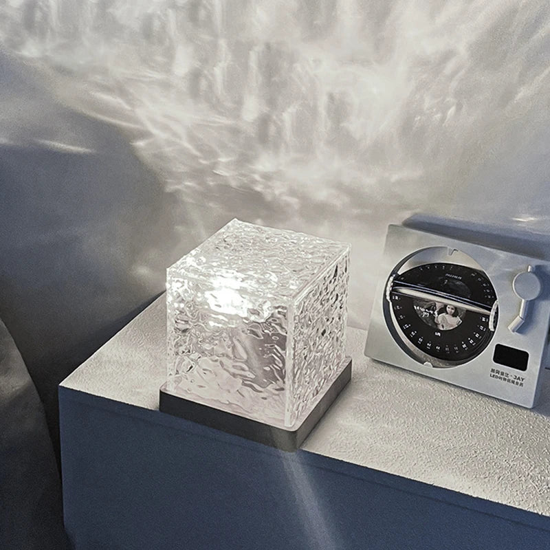 Lampe cube à ondulations d'eau – cube transparent éteint posé sur un meuble