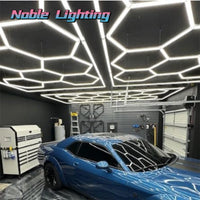 Plafonnier LED hexagonal – hexagones lumineux au plafond d'un garage, au-dessus d'une voiture bleue