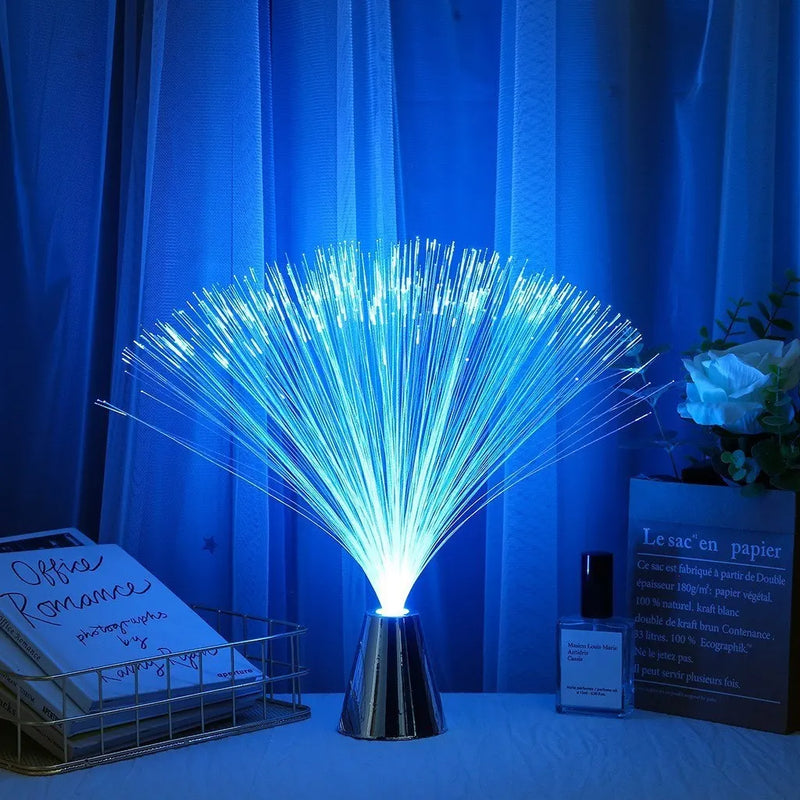 Lampe fibre optique – gerbe bleue sur une table devant des rideaux bleus