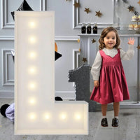 Lettre marquee 120 cm – la lettre L allumée à côté d'une petite fille
