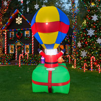 Père Noël gonflable en montgolfière – vue en contre-plongée dans un jardin
