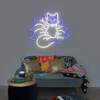Néon renard kitsune – coloris blanc et bleu allumé au-dessus d'un canapé
