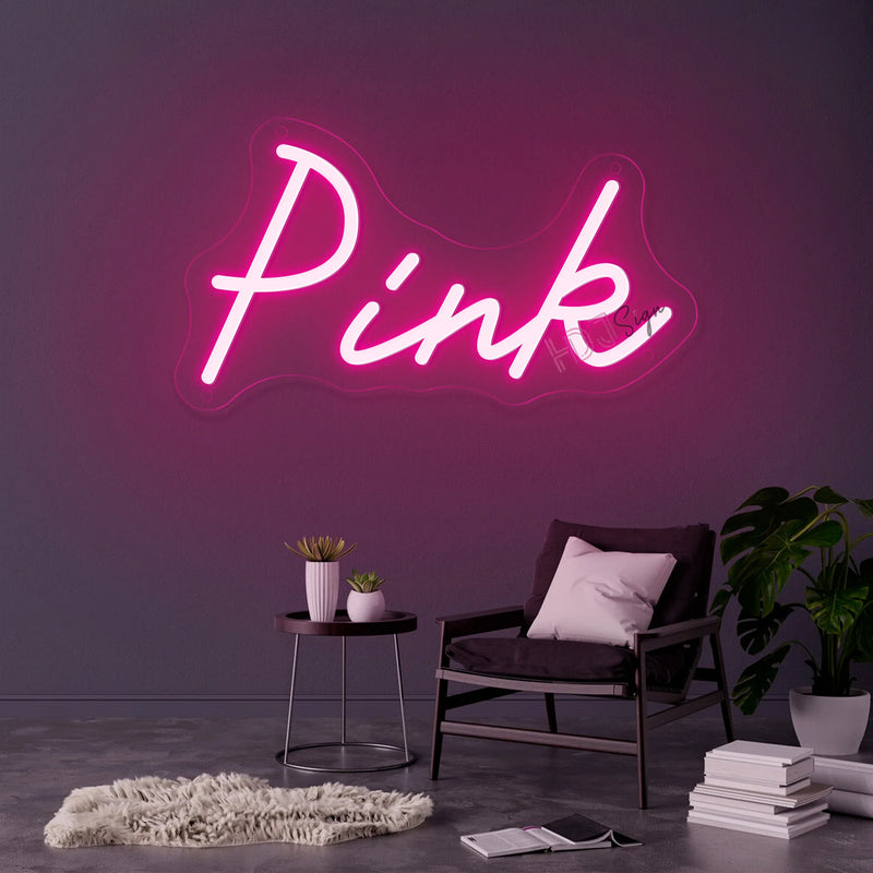 Néon prénom personnalisé cœur ou couronne – texte rose sur un mur gris au-dessus d'un fauteuil