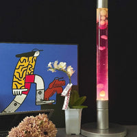Lampe à lave tube 55 cm – version à liquide rose sur un meuble
