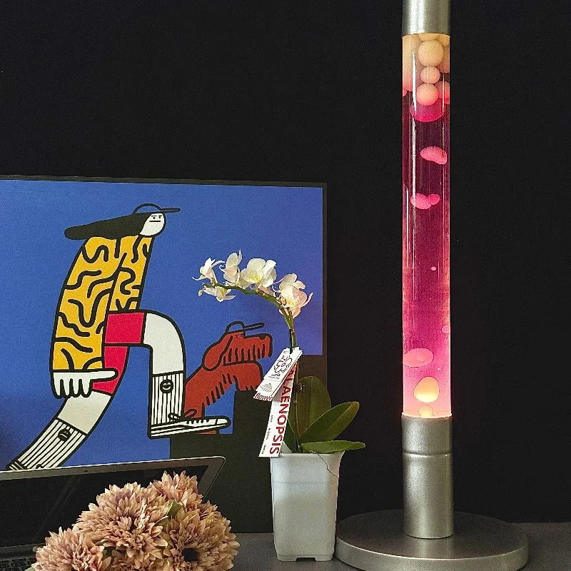 Lampe à lave tube 55 cm – version à liquide rose sur un meuble