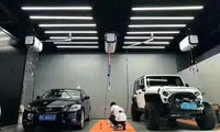 Barres LED murales de détailing – barres LED en lignes au plafond d'un atelier, deux véhicules dessous