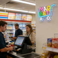 Enseigne néon MARKET chariot de courses – au-dessus d'une caisse de commerce de proximité
