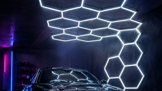 Éclairage LED hexagonal au plafond d'un garage, au-dessus d'une voiture noire