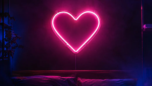 Néon LED rose en forme de cœur au-dessus d'un lit